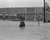 A man and a woman fight against the current of the Paxton Creek at 10th & Market Streets.